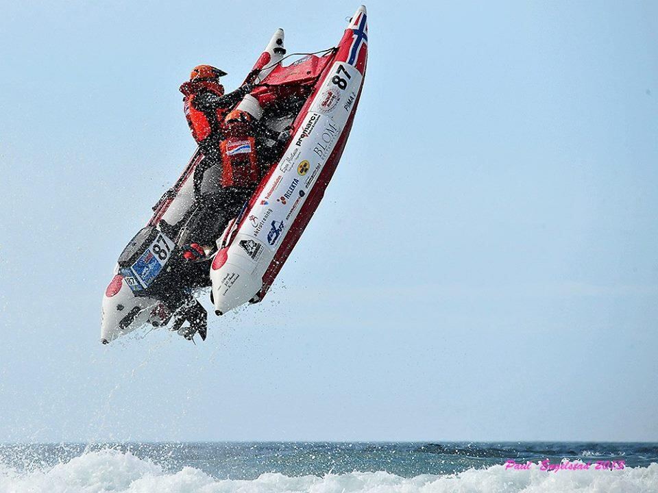 Aquarius race boat airborne off a wave, race number 87